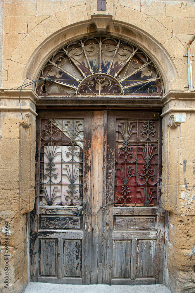 Fototapeta premium Old historical colorful doors and shutters made of wrought iron and wood. Old historical wooden doors in Cyprus. Doors and shutters of historical stone houses in Nicosia.