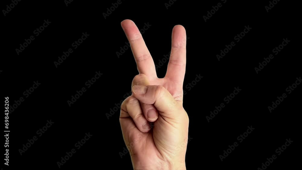 Close up shot of a male hand throwing a classic peace sign, against a plain black background Close up shot of a male hand throwing a classic peace sign, against a plain black background