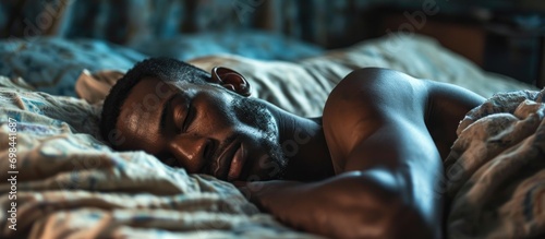 African American man peacefully sleeping in bed, relaxed and rested. #698441687