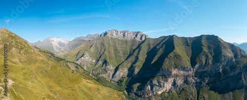 The Mountains around Gavarnie Gedre in the arid green countryside , Europe, France, Occitanie, Hautes-Pyrenees, in summer on a sunny day. photo