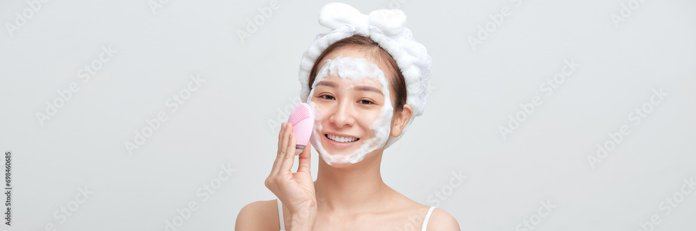 Φωτογραφία Panorama of asian female applying foamy cosmetic product on face during skincare