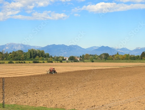 tractor in the middle of the plow field during the sowing period in the Po Valley in Italy