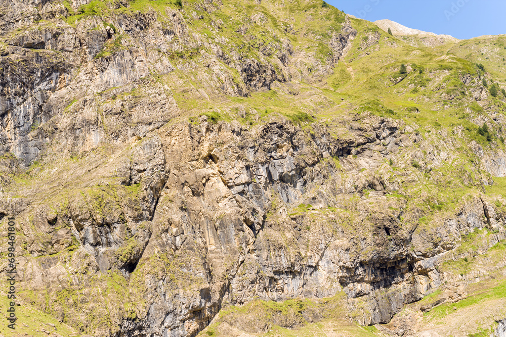 The barren rocky mountains in the middle of the countryside , Europe, France, Occitanie, Hautes-Pyrenees, in summer on a sunny day. The barren rocky mountains in the middle of the countryside , Europe, France, Occitanie, Hautes-Pyrenees, in summer on a sunny day.