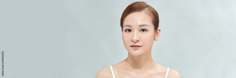 Fototapeta premium Banner with happy Asian female face with natural skin on white background