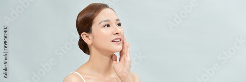 Asian woman has a lovely face is feeling happy with her perfect skin touch her face. Banner