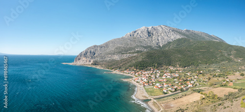 The town on the rocky coast in the middle of green countryside , Europe, Greece, Aetolia Acarnania, Kato Vasiliki towards Patras, by the Ionian Sea, in summer on a sunny day.