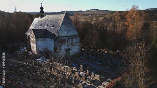 Aerial view of a gothic church surrounded by graves in the Šumava landscape of Velhartice photo