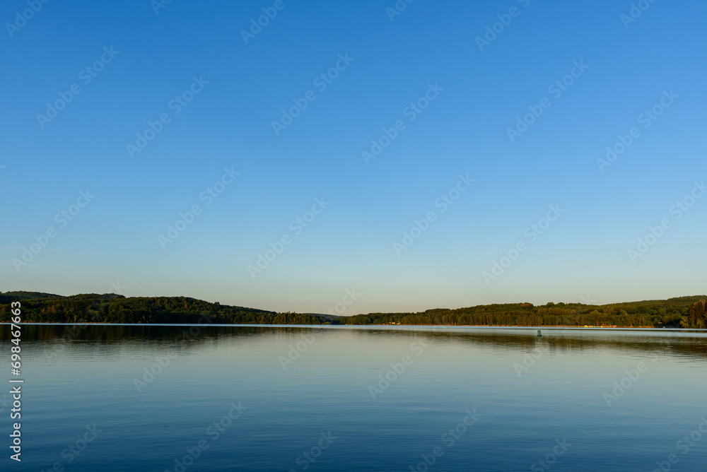 Lac des Settons amidst its green countryside in Europe, France, Burgundy, Nievre, towards Chateau Chinon, in summer on a sunny day. Lac des Settons amidst its green countryside in Europe, France, Burgundy, Nievre, towards Chateau Chinon, in summer on a sunny day.