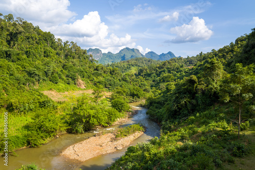 A river in the middle of the green mountains, in Asia, Vietnam, Tonkin, between Son La and Dien Bien Phu, in summer, on a sunny day.