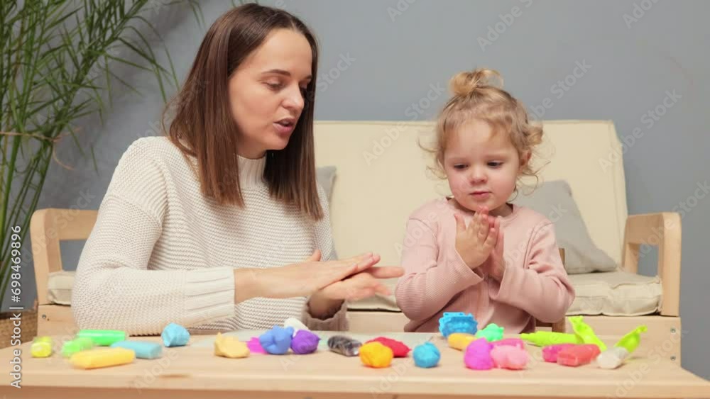 Family sculpture time. Child's creative development. Fun with colorful clay. Caucasian kid girl and mother playing colorful clay plasticine together in home interior Family sculpture time. Child's creative development. Fun with colorful clay. Caucasian kid girl and mother playing colorful clay plasticine together in home interior