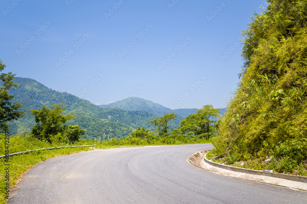 An asphalt road in the middle of the countryside and mountains, in Asia, Vietnam, Tonkin, between Dien Bien Phu and Lai Chau, in summer, on a sunny day. An asphalt road in the middle of the countryside and mountains, in Asia, Vietnam, Tonkin, between Dien Bien Phu and Lai Chau, in summer, on a sunny day.