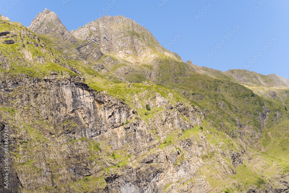 The barren rocky mountains in the middle of the countryside , Europe, France, Occitanie, Hautes-Pyrenees, in summer on a sunny day. The barren rocky mountains in the middle of the countryside , Europe, France, Occitanie, Hautes-Pyrenees, in summer on a sunny day.