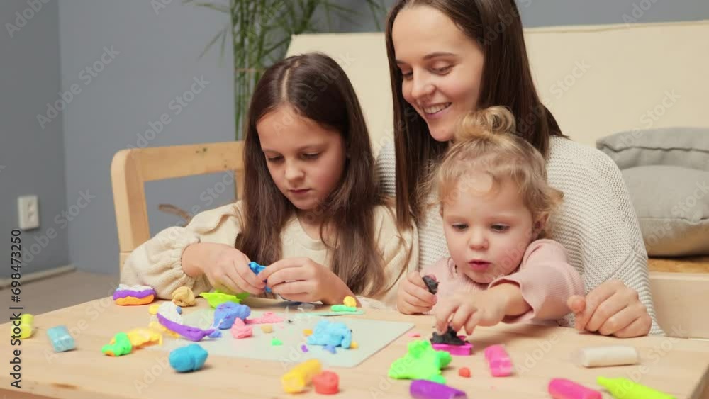 Creating with infants. Art and education blend. Schoolgirl in art class. Fun with colorful dough. Creative playroom moments. Children and their mother playing colorful clay plasticine at home Creating with infants. Art and education blend. Schoolgirl in art class. Fun with colorful dough. Creative playroom moments. Children and their mother playing colorful clay plasticine at home