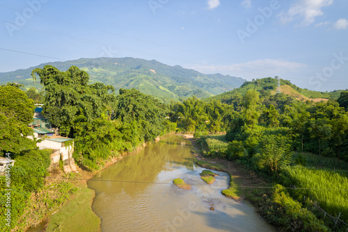 A river among green forests and mountains in the countryside  Asia  Vietnam  Tonkin  Dien Bien Phu  in summer  on a sunny day.