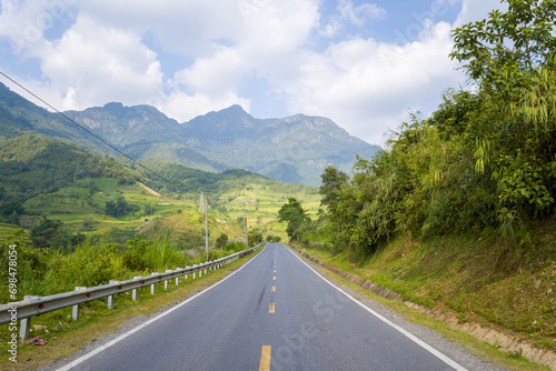 An asphalt road in the middle of the countryside and mountains, in Asia, Vietnam, Tonkin, between Lai Chau and Sapa, in summer, on a sunny day. © Florent