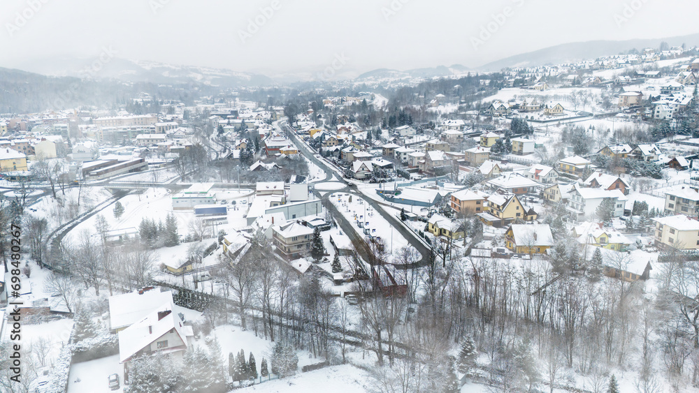 Drone shot of a small town named Limanowa in mountains in Poland covered with fog and snow