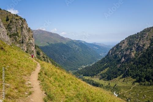 A hiking path in the green countryside , in Europe, in France, Occitanie, in the Hautes-Pyrenees, in summer, on a sunny day.