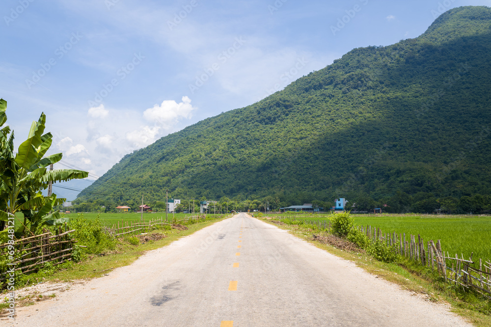 A road crosses mountains and traditional villages , in Asia, in Vietnam, in Tonkin, towards Hanoi, in Mai Chau, in summer, on a cloudy day. A road crosses mountains and traditional villages , in Asia, in Vietnam, in Tonkin, towards Hanoi, in Mai Chau, in summer, on a cloudy day.