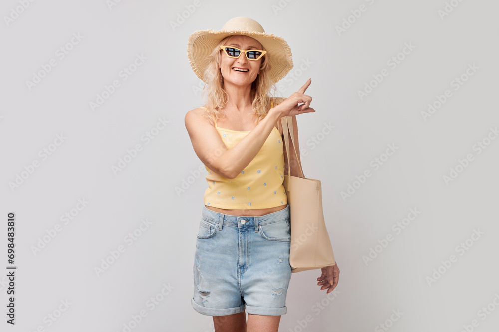 Beautiful mature woman 50 years old pointing finger aside, demonstrating empty space for product or text isolated on white studio background Beautiful mature woman 50 years old pointing finger aside, demonstrating empty space for product or text isolated on white studio background