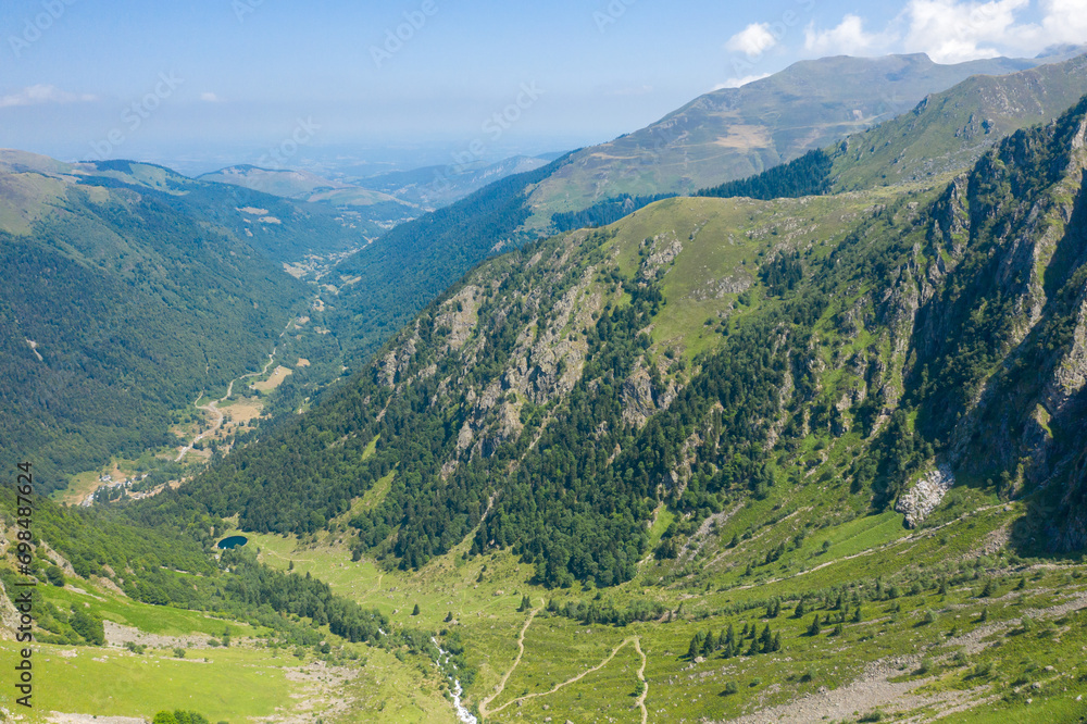 The Valley of Espone in the middle of the mountains and its green countryside , in Europe, in France, Occitanie, in the Hautes-Pyrenees, in summer, on a sunny day.