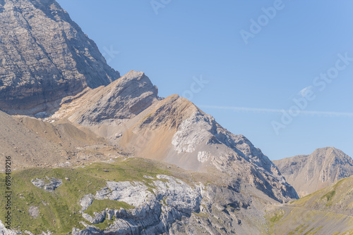 The Mountains around Gavarnie Gedre in the arid green countryside , Europe, France, Occitanie, Hautes-Pyrenees, in summer on a sunny day. photo