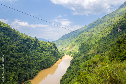 The red river in the middle of the green mountains, in Asia, Vietnam, Tonkin, between Dien Bien Phu and Lai Chau, in summer, on a sunny day. photo