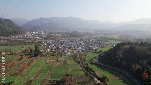 Aerial view of Chinese ancient village, Lucun, Hongcun, Anhui, China. Drone fly view of traditional villages in sunny autumn morning, colorful autumn agriculture field, 4k real time footage. photo