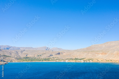 The sandy beach at the foot of the arid mountains   in Europe  Greece  Crete  Kato Zakros  By the Mediterranean Sea  in summer  on a sunny day.