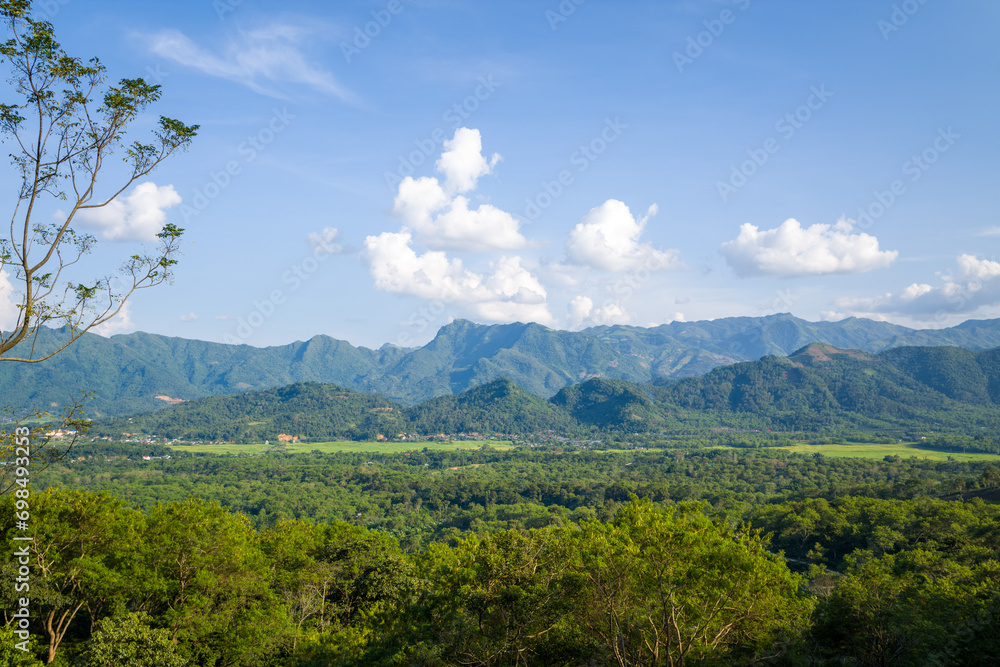 Fototapeta premium The green rice fields in the middle of forests and karst mountain peaks, in Asia, Vietnam, Tonkin, between Son La and Dien Bien Phu, in summer, on a sunny day.
