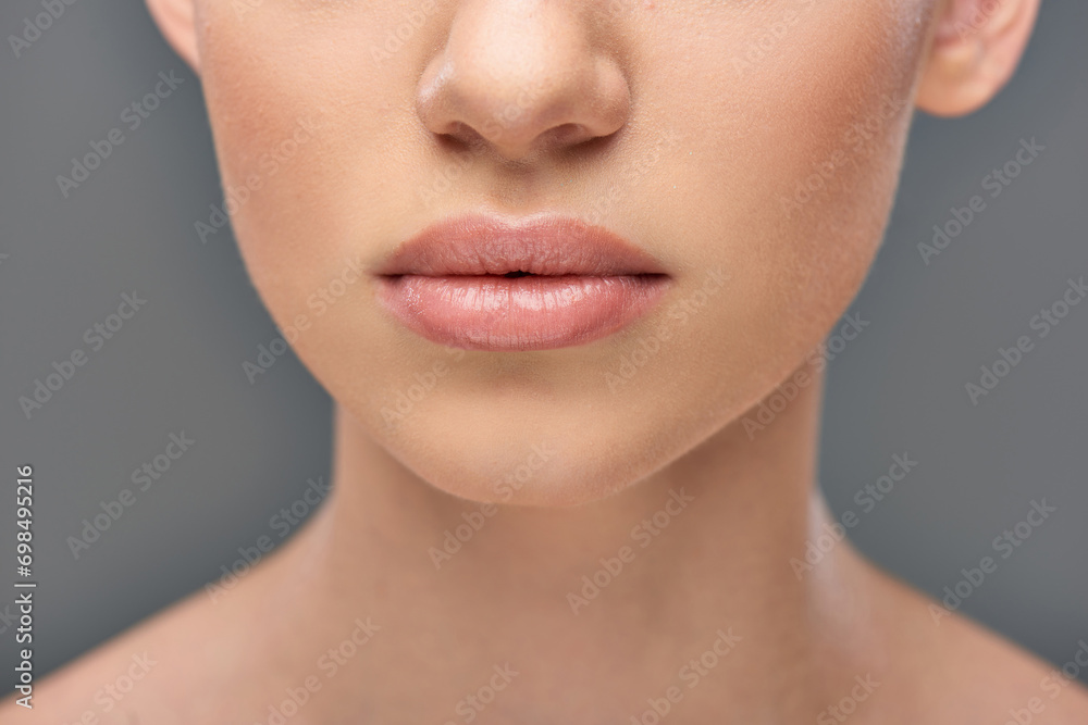 close up of young woman with juicy lips and perfect skin posing on grey background, youth and beauty close up of young woman with juicy lips and perfect skin posing on grey background, youth and beauty