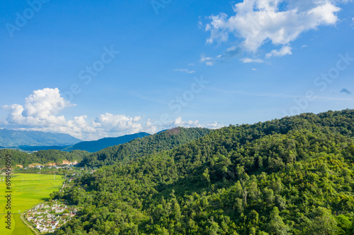 The traditional villages in the middle of the green and yellow rice fields in the valley, Asia, Vietnam, Tonkin, Dien Bien Phu, in summer, on a sunny day.