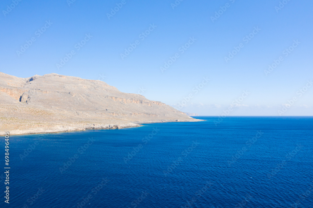 The barren rocky coast and mountains , in Europe, Greece, Crete, towards Sitia, By the Mediterranean sea, in summer, on a sunny day.