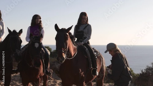 woman serving wine to friends riding horses photo