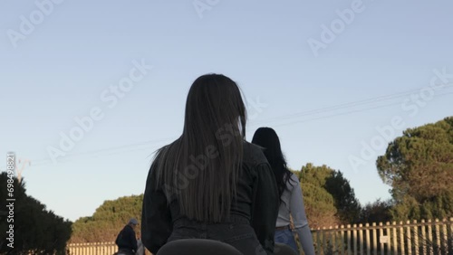 beautiful young woman riding a horse looking back at camera
