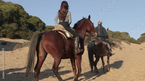 side view of women riding horses in the countryside during vacation