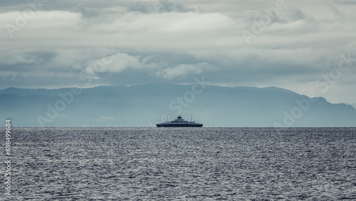A ferry sailing on the Trondheim Fjord. Dramatic clouds before storm and mountains.