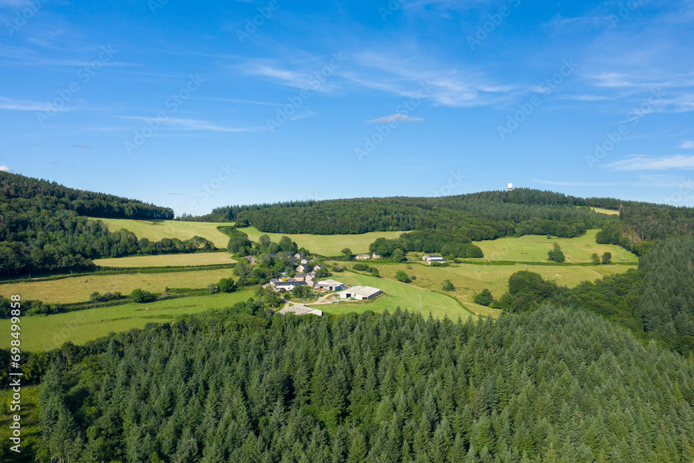 The countryside with its forests and green fields in Europe, France, Burgundy, Nievre, towards Chateau Chinon, in summer, on a sunny day.