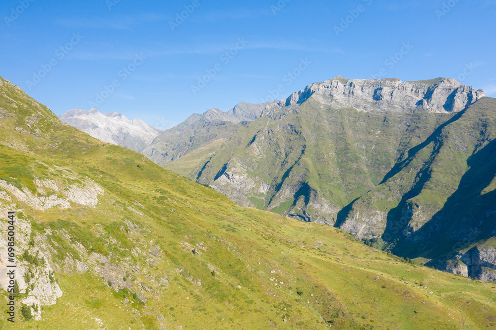 The Mountains around Gavarnie Gedre in the arid green countryside , Europe, France, Occitanie, Hautes-Pyrenees, in summer on a sunny day.