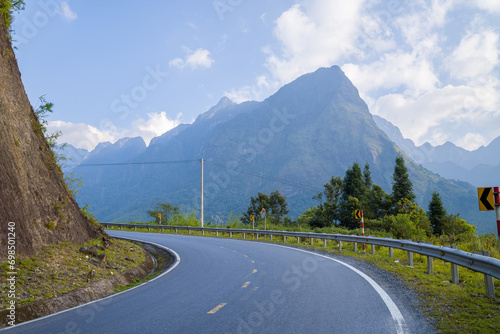 An asphalt road in the middle of the countryside and mountains, in Asia, Vietnam, Tonkin, between Lai Chau and Sapa, in summer, on a sunny day. photo