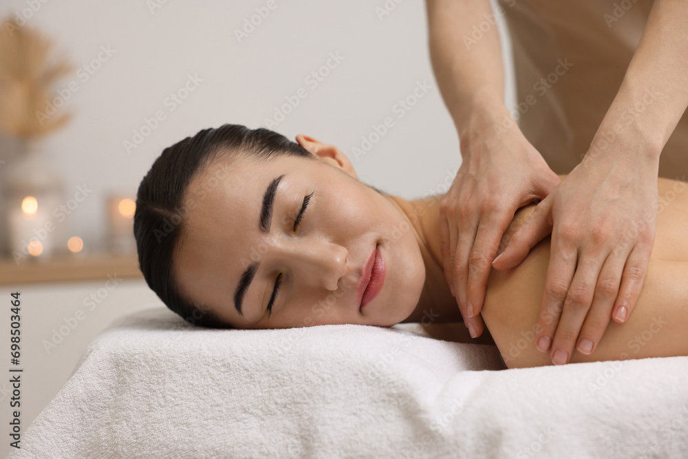 Woman receiving back massage on couch in spa salon Woman receiving back massage on couch in spa salon