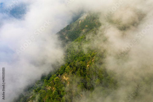 The green countryside under the clouds in Europe, France, in the Pyrenees, in summer, on a sunny day.