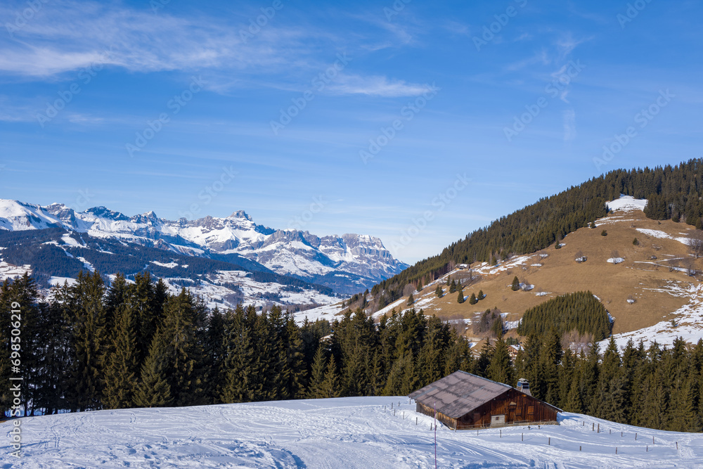 A mountain chalet facing the Chaine des Aravis in Europe, France, Rhone Alpes, Savoie, Alps, in winter, on a sunny day.