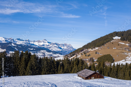 A mountain chalet facing the Chaine des Aravis in Europe, France, Rhone Alpes, Savoie, Alps, in winter, on a sunny day. © Florent