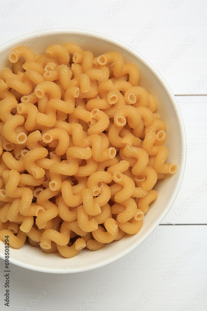 Raw cavatappi pasta in bowl on white wooden table, top view Raw cavatappi pasta in bowl on white wooden table, top view