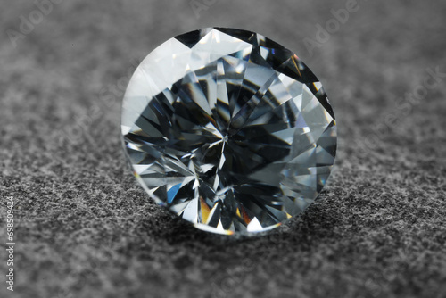Beautiful shiny diamond on grey background, closeup