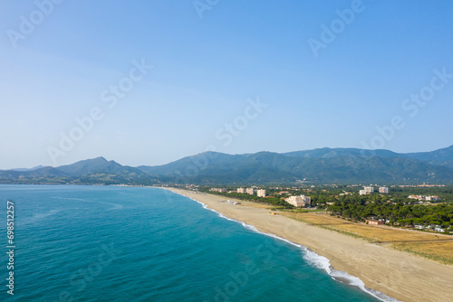 The white sand beach on the green coast in Europe, France, Occitanie, Pyrenees Orientales, Argeles, By the Mediterranean Sea, in summer, on a sunny day.