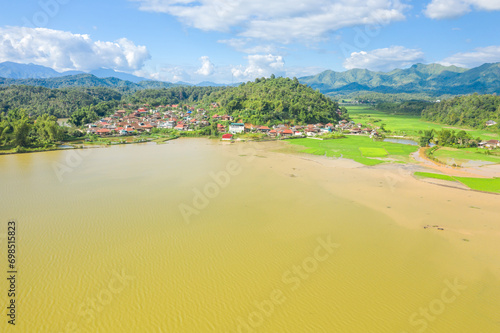 Fototapeta Naklejka Na Ścianę i Meble -  A traditional village by a lake and flooded rice fields in the middle of the mountains, Asia, Vietnam, Tonkin, Dien Bien Phu, in summer, on a sunny day.