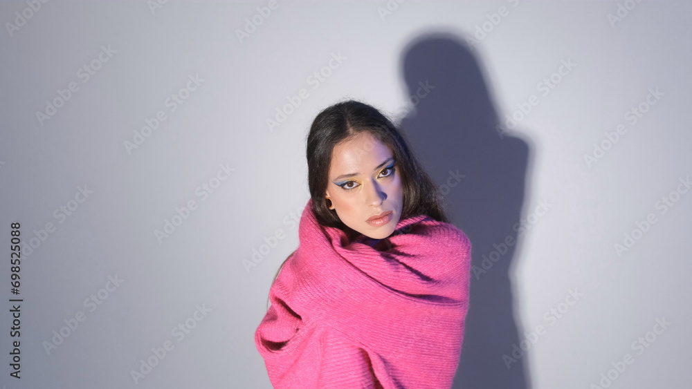 a girl in a red sweater poses on a light background. a girl in a red sweater poses on a light background.