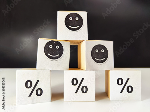 Konstfotografi Wooden cubes in a column and a row with white signs with a smiley sign, a percentage