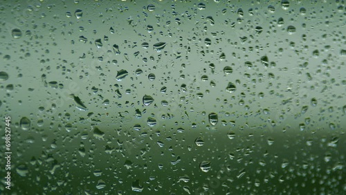 Rain Falls On Clear Glass. Streams Of Raindrops On Window Glass. Rack focus. photo